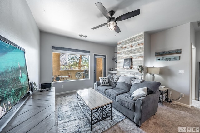 carpeted living room with a ceiling fan, visible vents, and baseboards