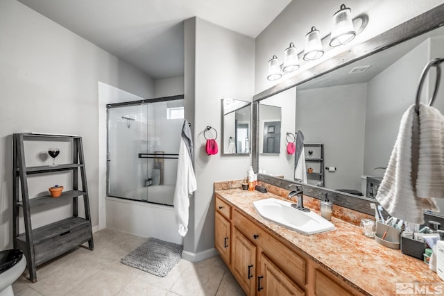 bathroom featuring tile patterned flooring, toilet, vanity, baseboards, and combined bath / shower with glass door