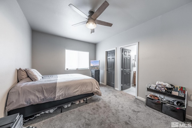 bedroom with a ceiling fan, light carpet, baseboards, and ensuite bathroom