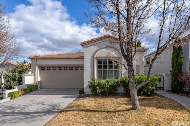 mediterranean / spanish home with a garage, concrete driveway, a tiled roof, and stucco siding