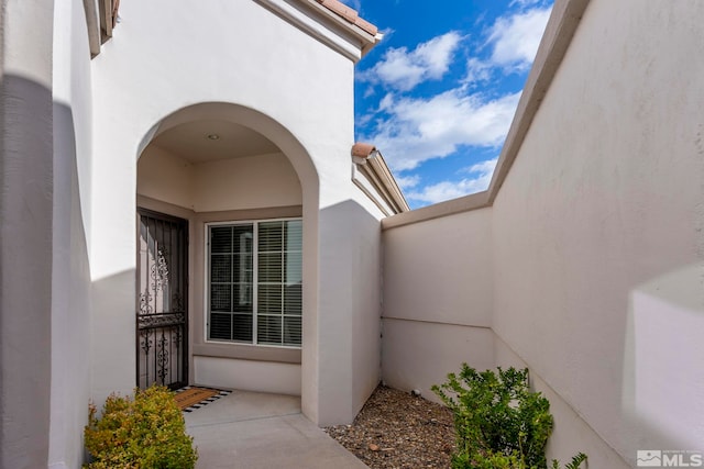 doorway to property featuring stucco siding