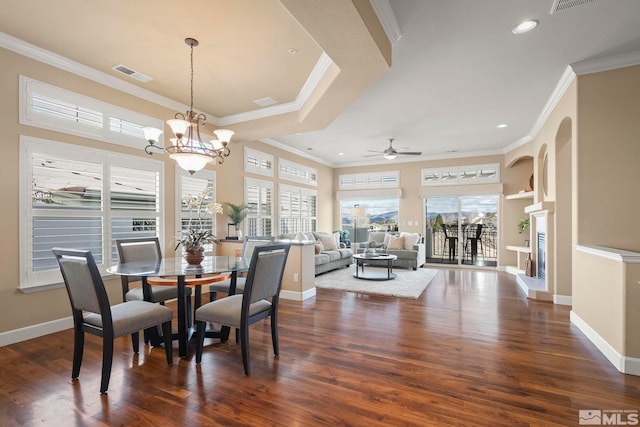 dining space with dark wood-style floors, a healthy amount of sunlight, visible vents, and ornamental molding