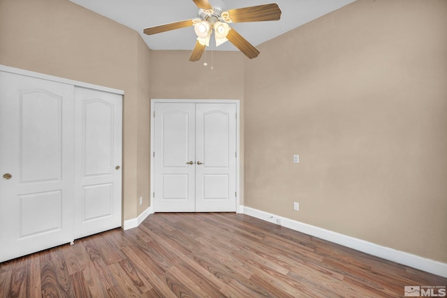 unfurnished bedroom with a closet, ceiling fan, baseboards, and wood finished floors