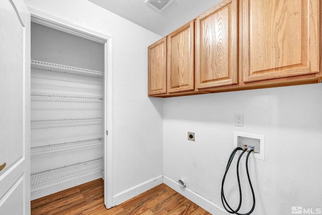 laundry area with cabinet space, visible vents, baseboards, wood finished floors, and washer hookup