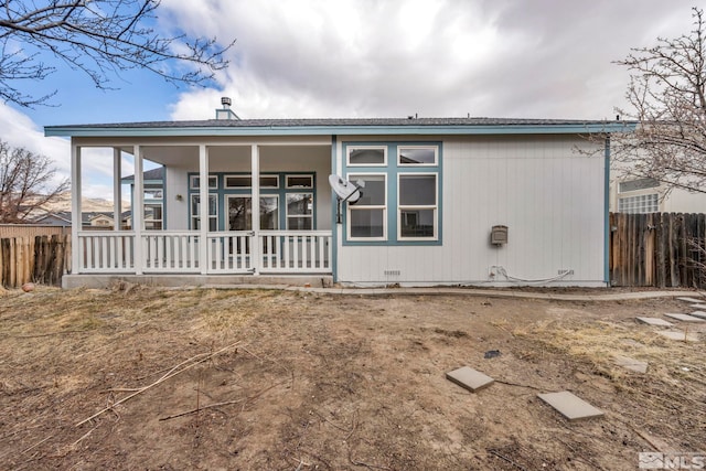 back of property with a porch and fence