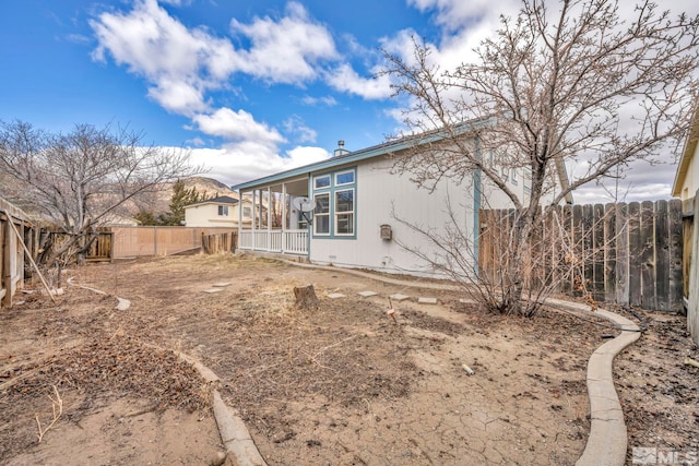 rear view of house featuring a fenced backyard