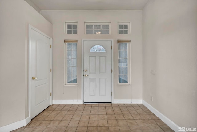 foyer entrance with baseboards and light tile patterned floors