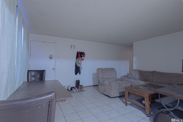 living area featuring a textured ceiling and light tile patterned flooring