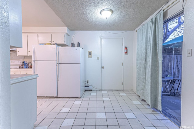 kitchen with light countertops, freestanding refrigerator, white cabinetry, light tile patterned flooring, and a textured ceiling