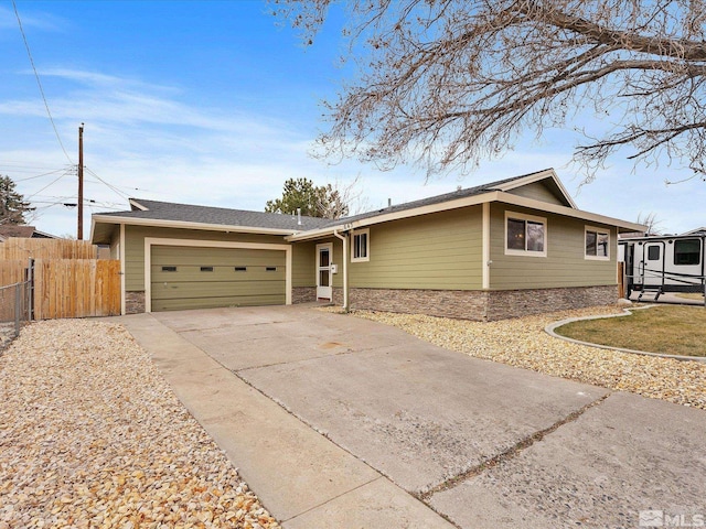 ranch-style house featuring driveway, a garage, and fence