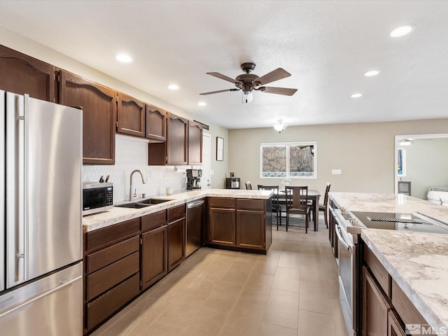 kitchen with ceiling fan, dark brown cabinetry, a sink, light countertops, and appliances with stainless steel finishes