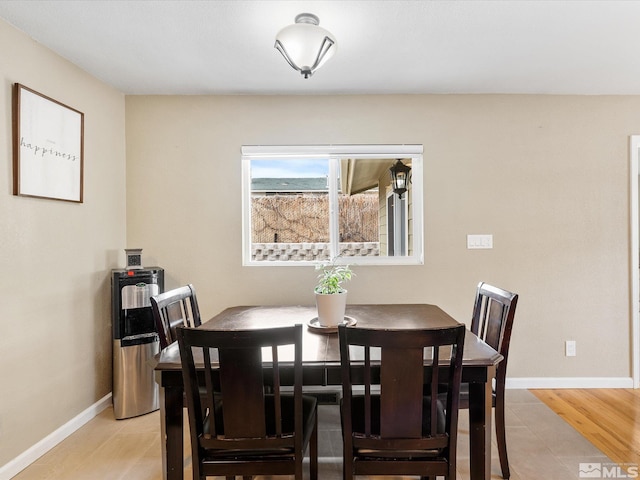 dining area featuring light wood-type flooring and baseboards