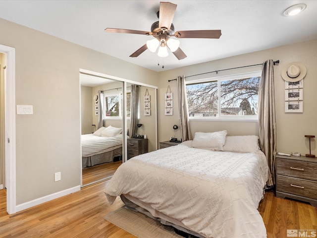 bedroom with multiple windows, light wood finished floors, and a closet