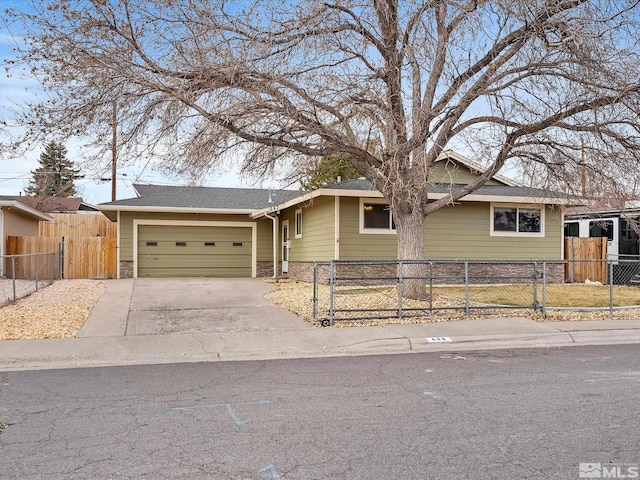 single story home featuring driveway, stone siding, a fenced front yard, and a garage