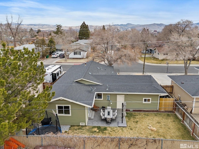 back of house with a yard, a patio, a mountain view, a residential view, and a fenced backyard