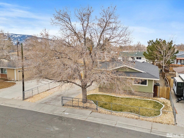 view of front of property featuring driveway, a front lawn, and fence