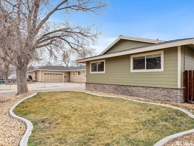 view of home's exterior with a garage, driveway, a lawn, and fence