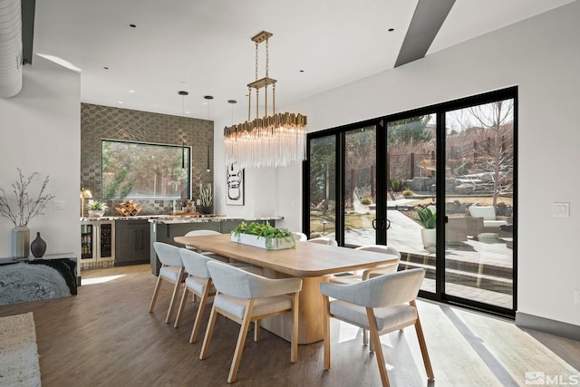 dining space featuring beverage cooler and light wood finished floors