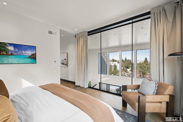 bedroom featuring baseboards, visible vents, and wood finished floors