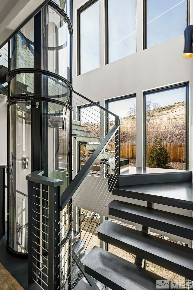 staircase featuring a high ceiling and a wealth of natural light