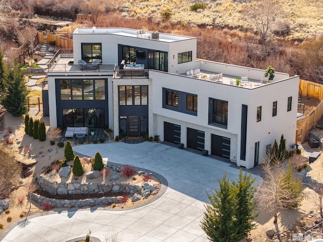 exterior space with a garage, driveway, fence, and stucco siding