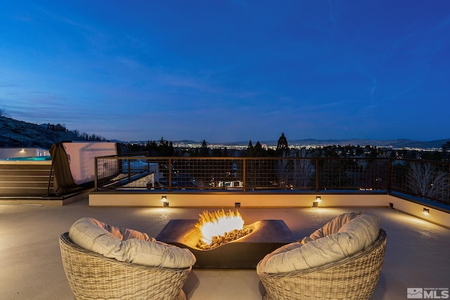 view of patio with an outdoor fire pit and a balcony