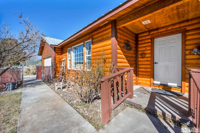 entrance to property with a garage and metal roof