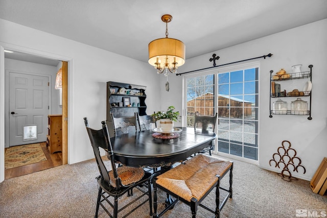 dining room with carpet flooring, a notable chandelier, and baseboards