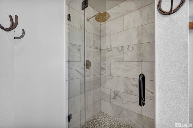 full bath featuring a stall shower and a textured wall