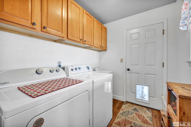 clothes washing area with a sink, dark wood finished floors, washing machine and clothes dryer, and cabinet space