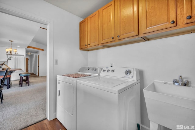 washroom featuring dark carpet, washing machine and dryer, cabinet space, and a sink