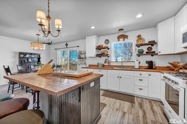 kitchen with white appliances, butcher block counters, a chandelier, open shelves, and a sink