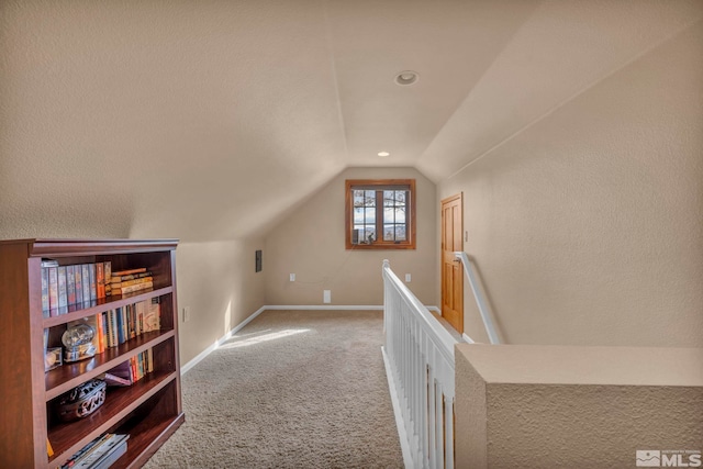 additional living space featuring carpet floors, baseboards, and vaulted ceiling