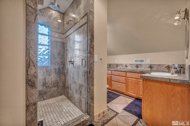 full bath featuring a textured wall, a shower stall, visible vents, and vanity