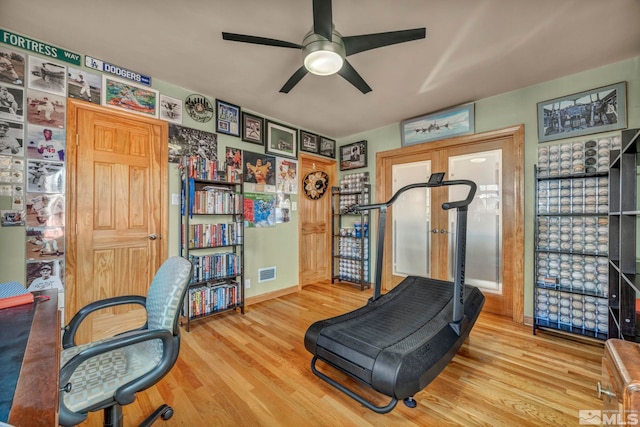 home office with wood finished floors, visible vents, and a ceiling fan