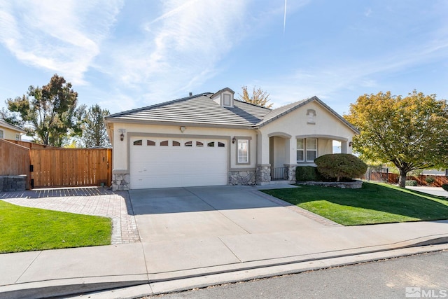 view of front facade with concrete driveway, an attached garage, fence, and a front yard