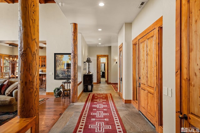 corridor featuring recessed lighting, visible vents, baseboards, and an inviting chandelier