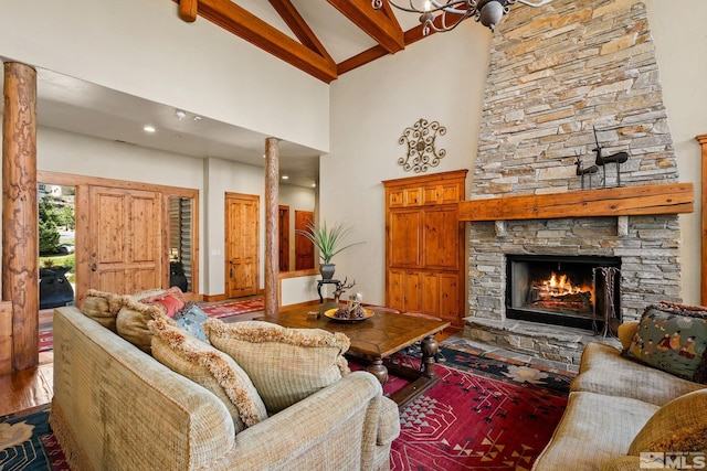 living area with high vaulted ceiling, a fireplace, wood finished floors, and beam ceiling