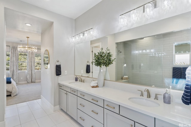 ensuite bathroom with a tile shower, tile patterned flooring, a sink, and connected bathroom