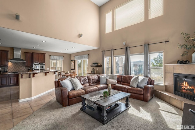 living area featuring recessed lighting, plenty of natural light, a tiled fireplace, and light tile patterned floors