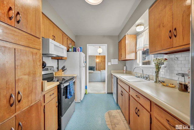 kitchen featuring a sink, light countertops, appliances with stainless steel finishes, light floors, and tasteful backsplash