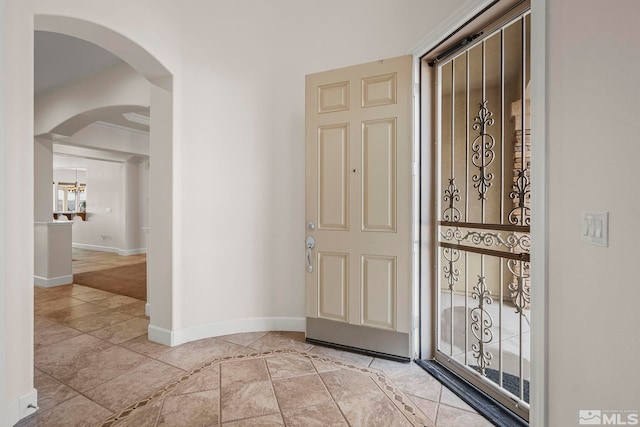 entryway with baseboards and arched walkways