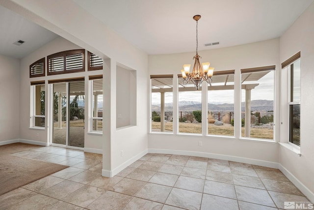 unfurnished dining area featuring a notable chandelier, visible vents, a mountain view, and baseboards