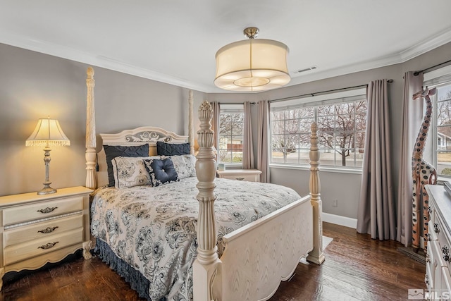 bedroom featuring dark wood finished floors, visible vents, crown molding, and baseboards