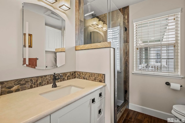 full bathroom featuring toilet, a shower stall, wood finished floors, and vanity