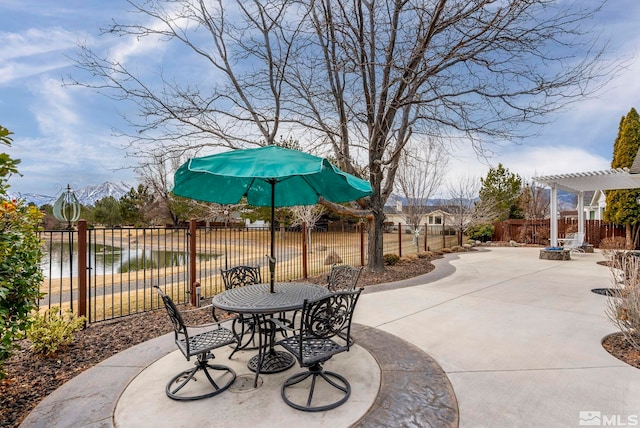 view of patio featuring outdoor dining area, fence, and a pergola