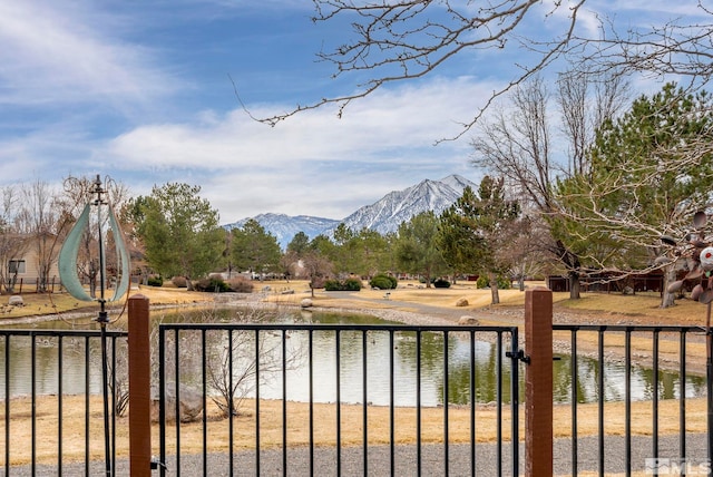 view of yard with fence and a water and mountain view