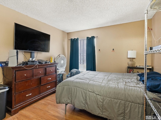 bedroom featuring light wood finished floors and a textured ceiling