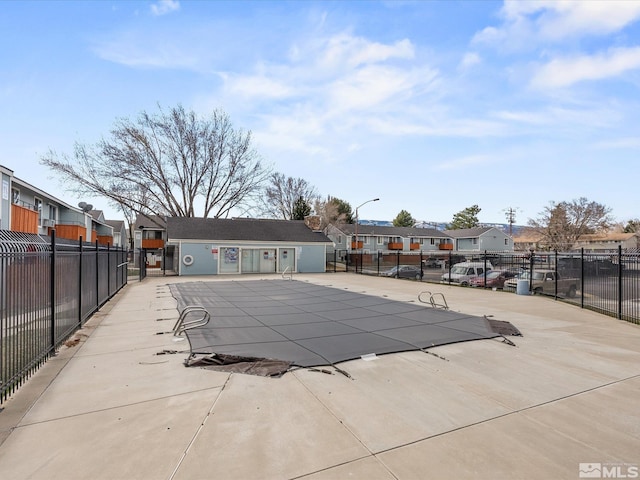 community pool with a residential view, fence, and a patio