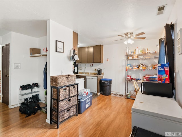 kitchen featuring visible vents, dishwasher, ceiling fan, light wood-style flooring, and light countertops